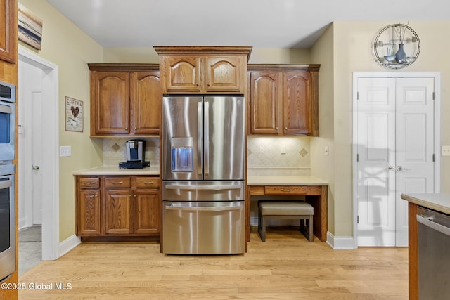 41 Jean Pl, Guilderland, NY 12303 - kitchen featuring appliances with stainless steel finishes, light wood finished floors, tasteful backsplash, and light countertops