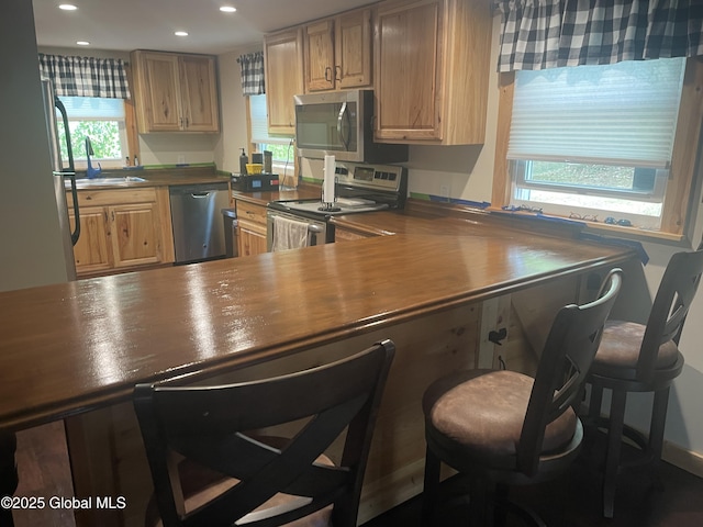 1469 S Shore Rd, Hadley, NY 12835 - kitchen with stainless steel appliances, dark countertops, recessed lighting, a sink, and a breakfast bar area