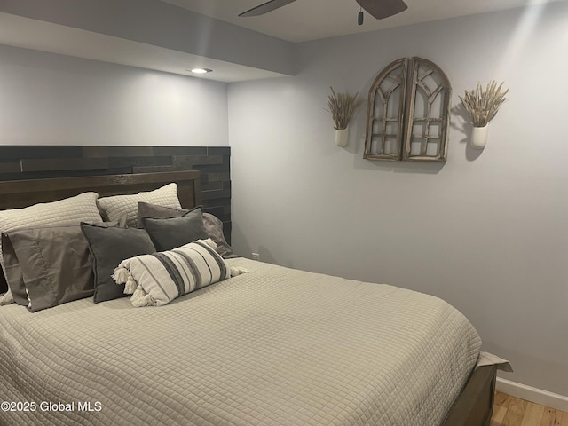 1469 S Shore Rd, Hadley, NY 12835 - bedroom featuring light wood-style flooring, baseboards, a fireplace, a ceiling fan, and recessed lighting