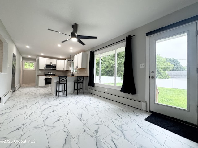 10 Kasper Dr, Colonie, NY 12211 - kitchen featuring stainless steel appliances, a baseboard radiator, a kitchen breakfast bar, white cabinetry, and light marble finish floors