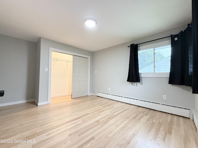 10 Kasper Dr, Colonie, NY 12211 - unfurnished bedroom with a baseboard radiator, light wood-style floors, baseboards, and a closet
