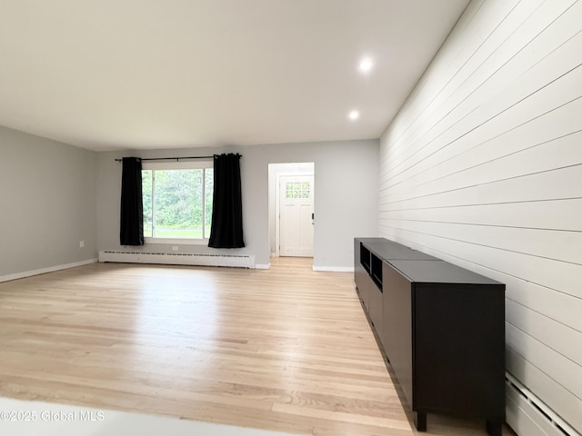 10 Kasper Dr, Colonie, NY 12211 - unfurnished living room with a baseboard radiator, light wood-style floors, baseboards, recessed lighting, and wood walls