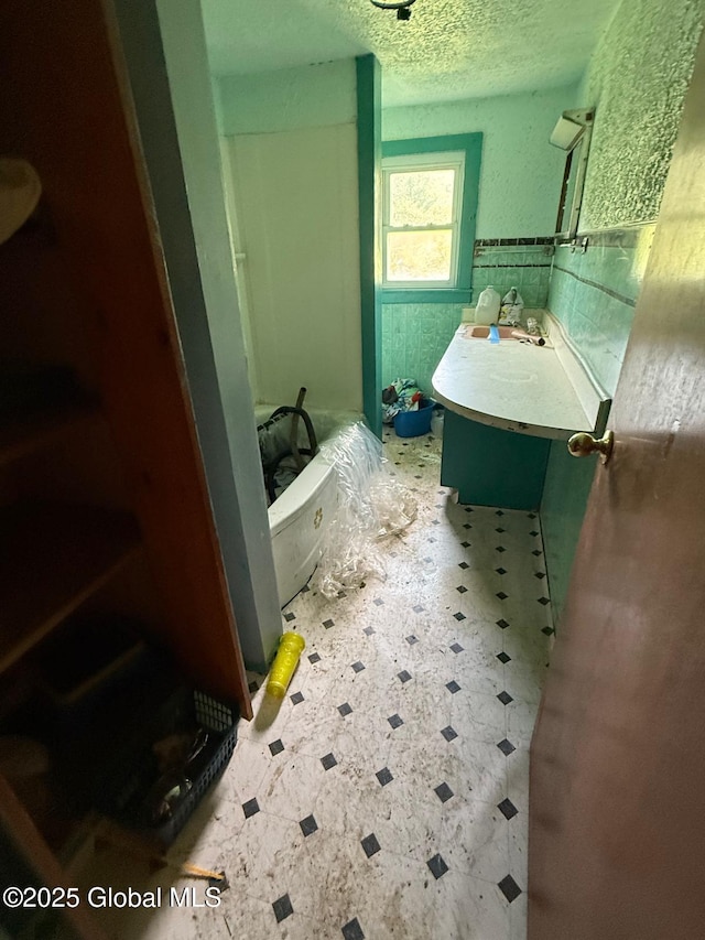 116 Coons Rd, Middleburgh, NY 12122 - full bath featuring a bath, tile patterned floors, a textured ceiling, wainscoting, and vanity