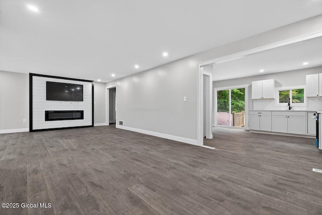 12 Haviland Ave, Glens Falls, NY 12801 - unfurnished living room with dark wood-style flooring, a sink, baseboards, and recessed lighting