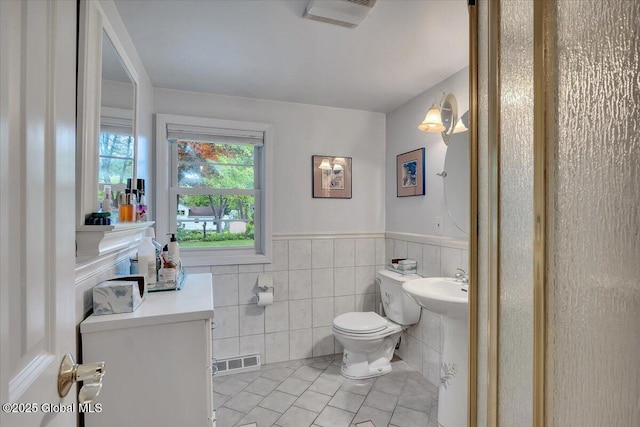 3083 E Old State Rd, Guilderland, NY 12303 - half bath featuring tile patterned flooring, tile walls, toilet, and a wainscoted wall