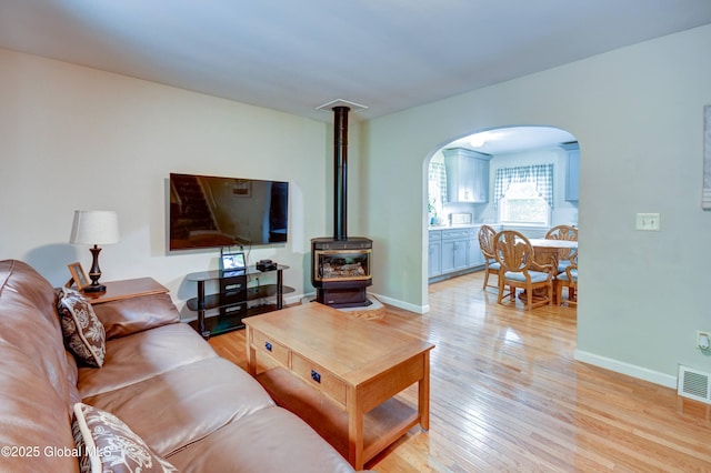 4 Tomohawk Pl, Johnstown, NY 12095 - living room with a wood stove, arched walkways, and light wood finished floors