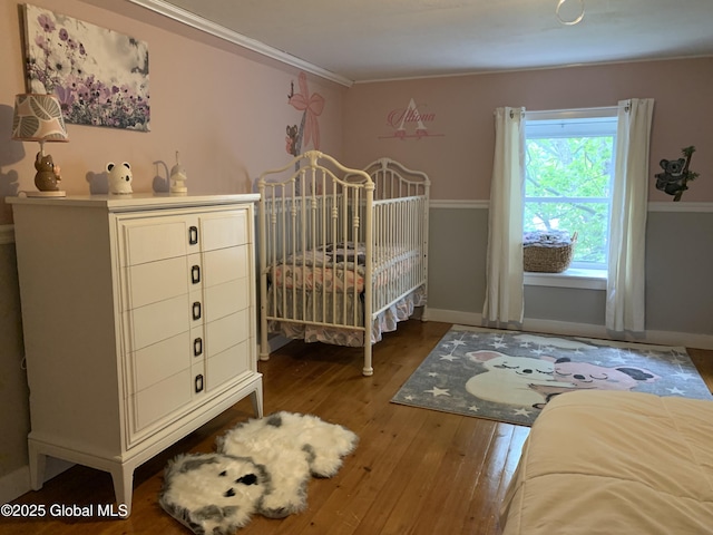 3 Meacham St, Port Henry, NY 12974 - bedroom with wood-type flooring, baseboards, a crib, and ornamental molding