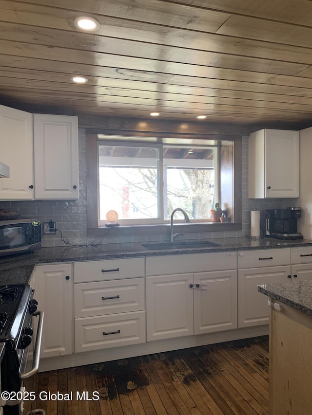 3 Meacham St, Port Henry, NY 12974 - kitchen featuring stainless steel appliances, white cabinetry, wooden ceiling, dark wood-style flooring, and backsplash