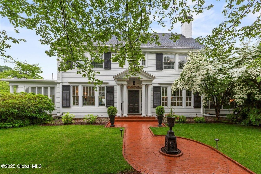 670 Western Ave, Albany, NY 12203 - colonial-style house featuring a chimney and a front lawn