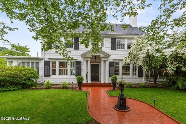 670 Western Ave, Albany, NY 12203 - colonial-style house featuring a chimney and a front lawn