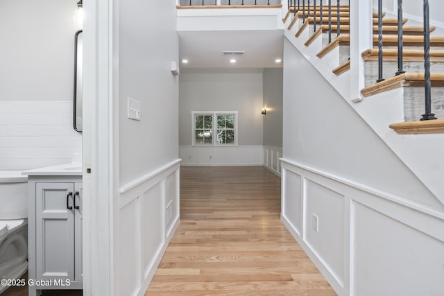 21 Jaipur Ln, Saratoga Springs, NY 12866 - stairway featuring a wainscoted wall, wood finished floors, a decorative wall, and recessed lighting