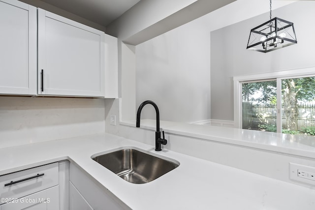 21 Jaipur Ln, Saratoga Springs, NY 12866 - kitchen with light countertops, white cabinets, a chandelier, and decorative light fixtures