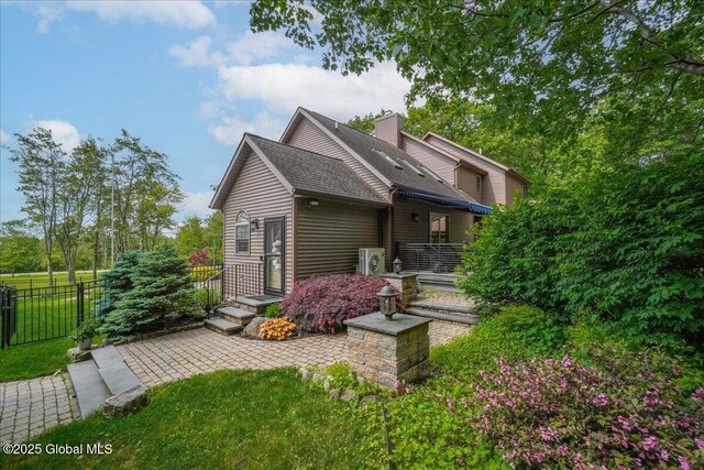 2034 Duanesburg Churches Rd, Duanesburg, NY 12053 - back of property featuring roof with shingles, a patio, and a chimney