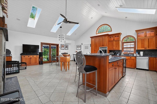 2034 Duanesburg Churches Rd, Duanesburg, NY 12053 - kitchen featuring a skylight, appliances with stainless steel finishes, open floor plan, brown cabinetry, and dark countertops