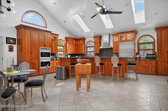 2034 Duanesburg Churches Rd, Duanesburg, NY 12053 - kitchen with a skylight, high vaulted ceiling, wall chimney exhaust hood, brown cabinetry, and double oven