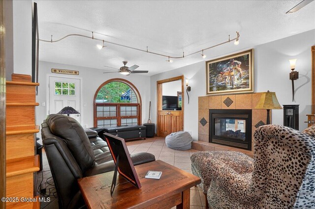 2034 Duanesburg Churches Rd, Duanesburg, NY 12053 - living room featuring stairs, a tile fireplace, rail lighting, and light tile patterned flooring