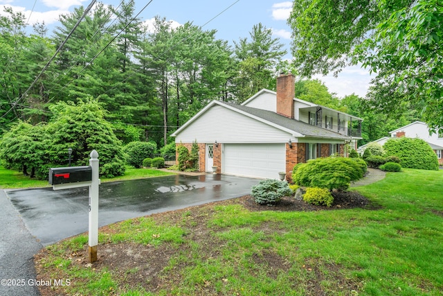19 Tamarack Ln, Colonie, NY 12309 - view of side of property featuring asphalt driveway, brick siding, an attached garage, a lawn, and a chimney