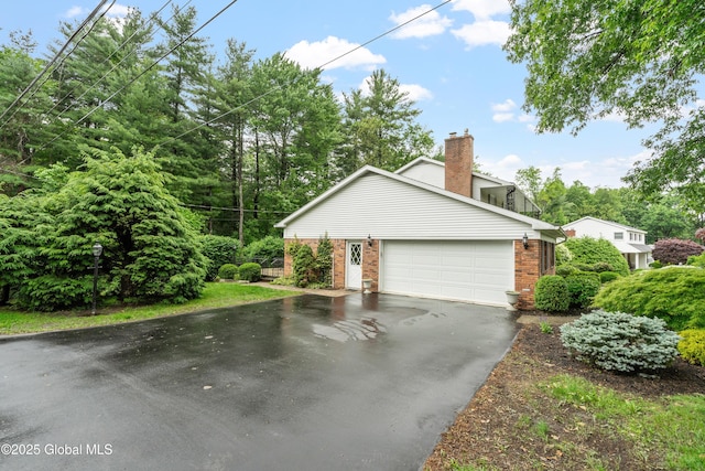 19 Tamarack Ln, Colonie, NY 12309 - view of home's exterior with brick siding, asphalt driveway, a garage, and a chimney