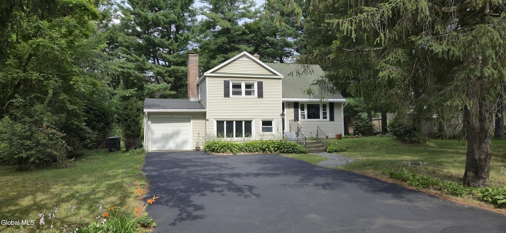 7 Patten Dr, Colonie, NY 12211 - view of front of home featuring asphalt driveway, a garage, a chimney, a front lawn, and roof with shingles