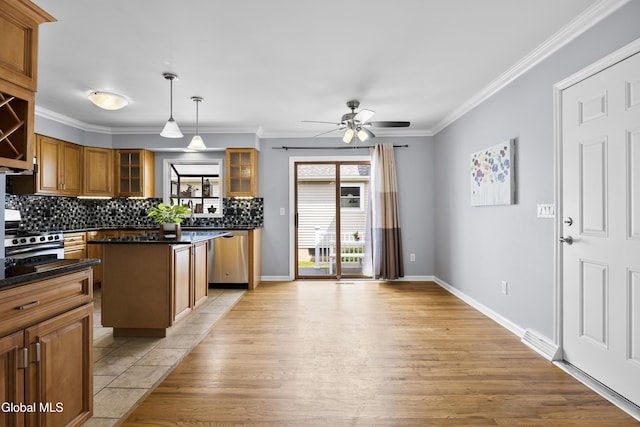 67 Victoria Way, Albany, NY 12209 - kitchen featuring dark countertops, decorative backsplash, stainless steel appliances, brown cabinets, and ceiling fan