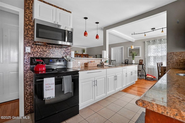 47 Mountainview Ter, North Greenbush, NY 12144 - kitchen with black electric range oven, stainless steel microwave, light tile patterned flooring, white cabinets, and tasteful backsplash