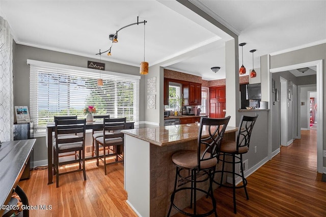 47 Mountainview Ter, North Greenbush, NY 12144 - kitchen featuring hardwood / wood-style flooring, a breakfast bar, crown molding, decorative light fixtures, and stone countertops