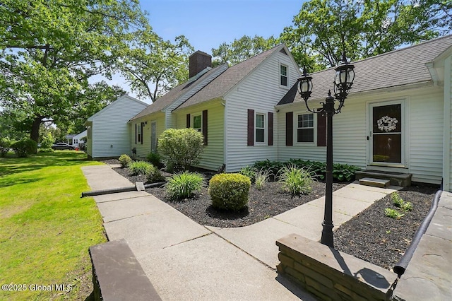 47 Mountainview Ter, North Greenbush, NY 12144 - view of front facade with a chimney, a front yard, and a shingled roof