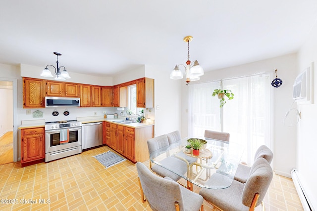 9 Arlene Ave, Guilderland, NY 12203 - kitchen with appliances with stainless steel finishes, a chandelier, a baseboard heating unit, light countertops, and brick patterned floors