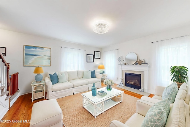 113 Fieldstone Dr, Niskayuna, NY 12304 - living area with wood finished floors, healthy amount of natural light, a fireplace with flush hearth, and stairs