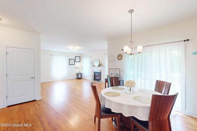 113 Fieldstone Dr, Niskayuna, NY 12304 - dining area featuring light wood-style flooring, a chandelier, and a glass covered fireplace