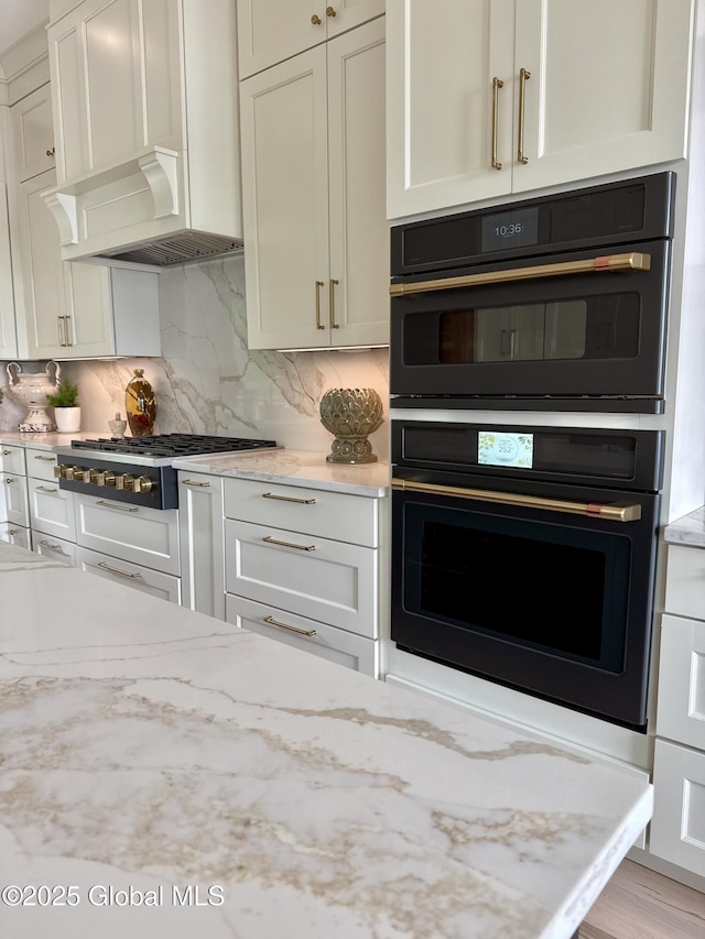 101 W High St, Ballston Spa, NY 12020 - kitchen featuring stainless steel gas cooktop, wall chimney exhaust hood, decorative backsplash, and white cabinetry