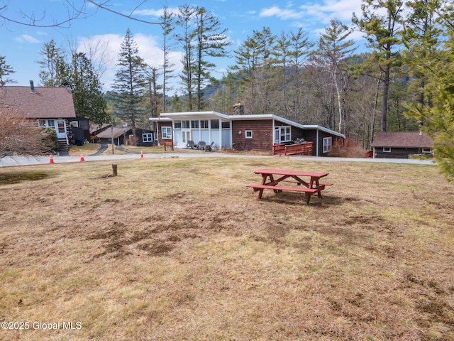 4A High Pines Ter, Warrensburg, NY 12817 - view of front facade with a front lawn, a chimney, and a sunroom