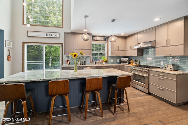 10 Overlook Dr, Wilton, NY 12831 - kitchen with high end range, under cabinet range hood, backsplash, light stone countertops, and a kitchen island