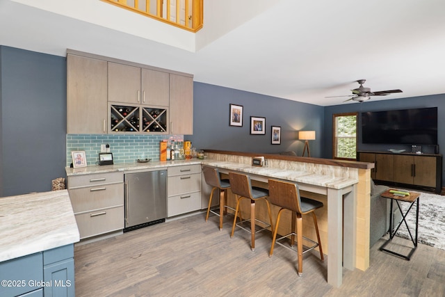 10 Overlook Dr, Wilton, NY 12831 - kitchen with fridge, a kitchen breakfast bar, a peninsula, light wood-style floors, and light countertops