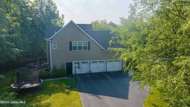 76 Hoffman Ct, Milton, NY 12020 - traditional home featuring a trampoline, asphalt driveway, a front lawn, and an attached garage