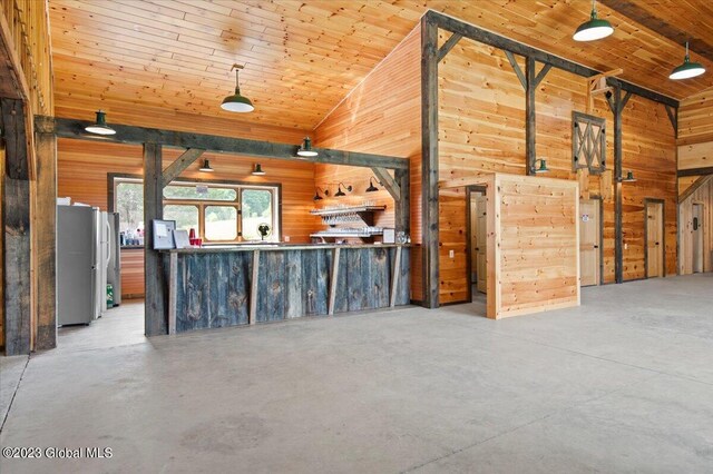 284 Edgemont Rd, Moriah, NY 12960 - unfurnished living room with wood walls, finished concrete flooring, wooden ceiling, and high vaulted ceiling