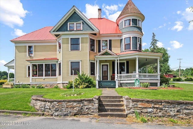 284 Edgemont Rd, Moriah, NY 12960 - victorian-style house with a porch, a chimney, a metal roof, and a front lawn