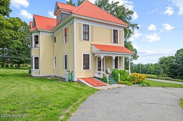 284 Edgemont Rd, Moriah, NY 12960 - view of front of home featuring covered porch, a metal roof, and a front lawn