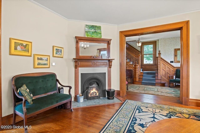 284 Edgemont Rd, Moriah, NY 12960 - sitting room with wood finished floors, stairs, ornamental molding, and a warm lit fireplace