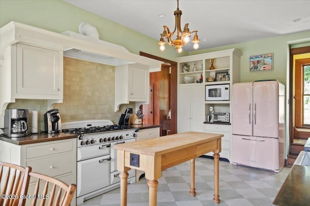 284 Edgemont Rd, Moriah, NY 12960 - kitchen with white appliances, dark countertops, light floors, decorative backsplash, and white cabinets