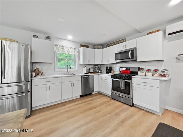 284 Edgemont Rd, Moriah, NY 12960 - kitchen with stainless steel appliances, light countertops, white cabinetry, decorative backsplash, and a wall mounted air conditioner
