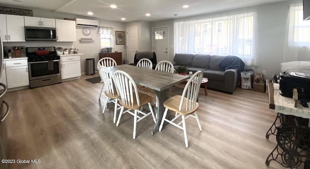 284 Edgemont Rd, Moriah, NY 12960 - dining room with light wood-style flooring, a wall mounted AC, and recessed lighting