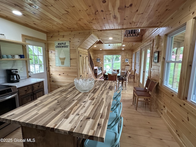 284 Edgemont Rd, Moriah, NY 12960 - dining room featuring wooden walls, wooden ceiling, light wood-type flooring, and recessed lighting