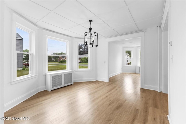 2321 1st Ave, Rotterdam, NY 12303 - unfurnished dining area with radiator heating unit, a chandelier, and light wood-style flooring