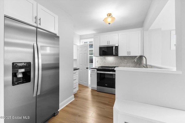 2321 1st Ave, Rotterdam, NY 12303 - kitchen with stainless steel appliances, white cabinets, tasteful backsplash, light wood finished floors, and light countertops