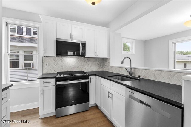 2321 1st Ave, Rotterdam, NY 12303 - kitchen with appliances with stainless steel finishes, dark countertops, white cabinetry, and decorative backsplash