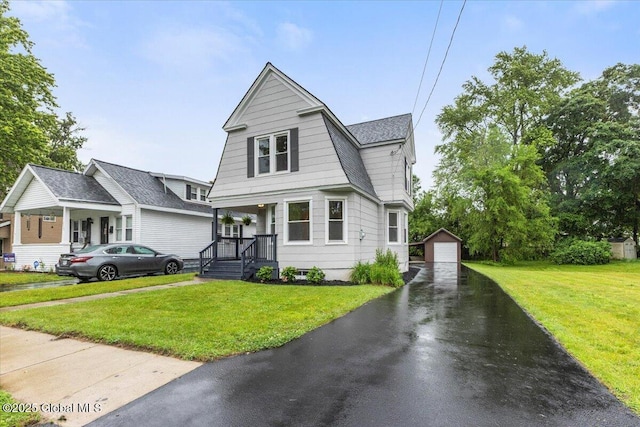 2321 1st Ave, Rotterdam, NY 12303 - view of front of house featuring an outdoor structure, a detached garage, asphalt driveway, and a front yard