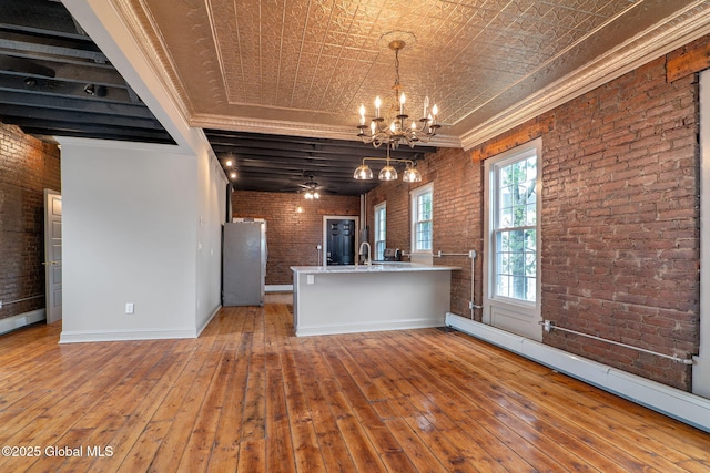 462-470 2nd Ave, Troy, NY 12182 - kitchen with brick wall, a baseboard radiator, freestanding refrigerator, a chandelier, and hardwood / wood-style flooring