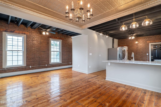 462-470 2nd Ave, Troy, NY 12182 - unfurnished living room featuring brick wall, ceiling fan, hardwood / wood-style flooring, beamed ceiling, and a chandelier