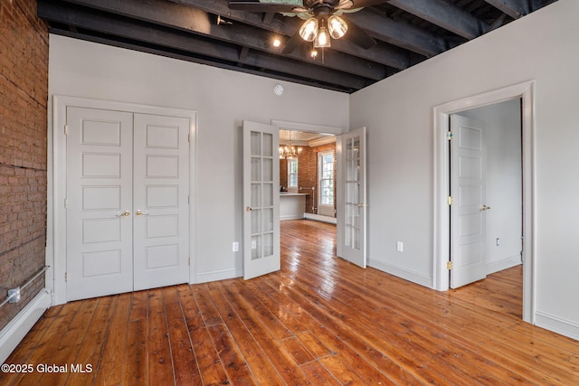 462-470 2nd Ave, Troy, NY 12182 - unfurnished bedroom with french doors, a chandelier, beam ceiling, wood-type flooring, and brick wall